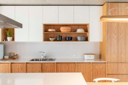 Detalle de la cocina anterior. La lámpara elegida dialoga perfectamente con los muebles y nichos en roble americano macizo y enchapado.