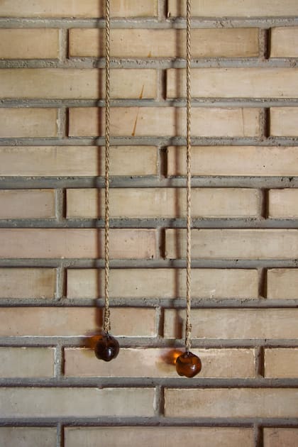 Detalle de los interruptores de luz de cuero trenzado y ambar en el salòn principal de la casa.