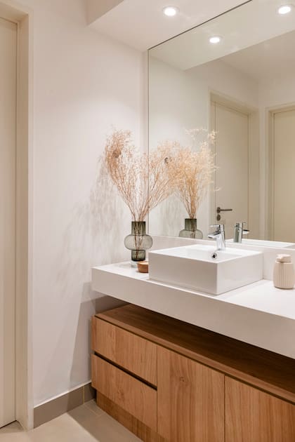 Detalles como el espejo, el mueble de guardado bajomesada y los objetos decorativos (Brambo) hicieron la diferencia.