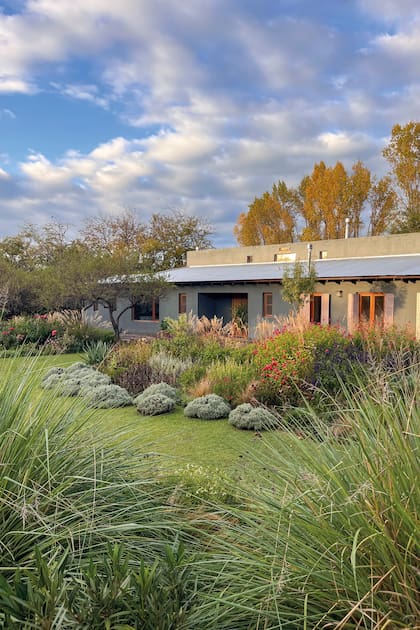 Detrás de la casa se aprecian los carolinos con colores otoñales