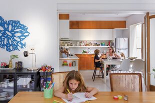 Detrás de la mesa de comedor, mueble vajillero de hierro y vidrio (Crate and Barrel) y calado en MDF pintado de Julia Masvernat (Tienda Inmaterial)