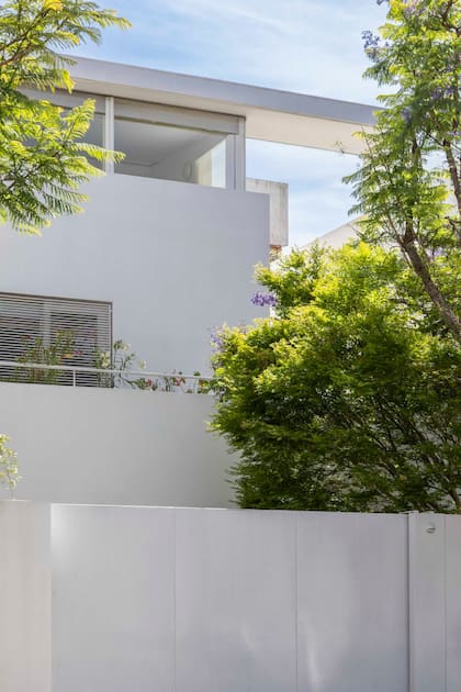 Detrás del portón tan blanco y limpio como la fachada, el tercer piso está ocupado por un amplio espacio de trabajo