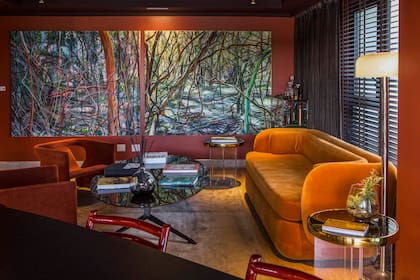 La gran obra de Adrián Paiva (Diderot. art) contiene los tonos de los sillones 'Cinta número cinco' de Alberto Churba (Retrodeco), el sofá (C'est Moi) y las cortinas Velvet color chocolate delante de las persianas horizontales de madera con galones del mismo tono (Hunter Douglas by Delia Mucci Cortinas).