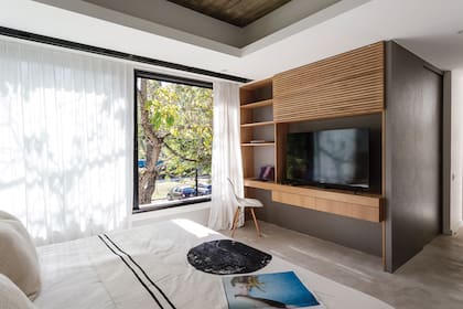 Detrás del varillado del mueble para TV y escritorio que César Lago diseñó para su cuarto, se esconde el equipo de aire acondicionado.
