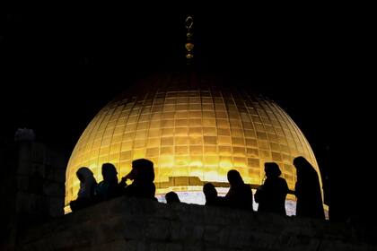 Devotas palestinas musulmanas rezan durante la Laylat al-Qadr, o la Noche del Destino, en el mes de ayuno de Ramadan, frente al domo de la Mezquita de la Roca, Jerusalén