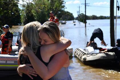 Di Smith es abrazada por su hija Heather después de que fuera evacuada de su casa en East Kurrajong en el noroeste de Sydney