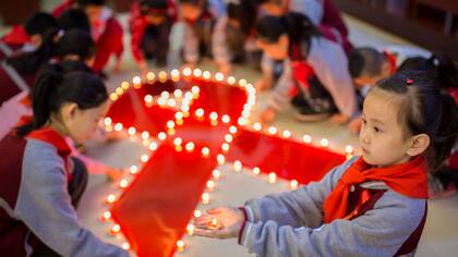 Un grupo de niños prende velas en un homenaje en una escuela primaria