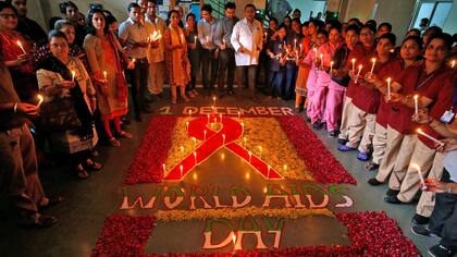  En Ahmedabad, India, varias personas se reúnen para conmemorar el Día Mundial de la Lucha contra el VIH