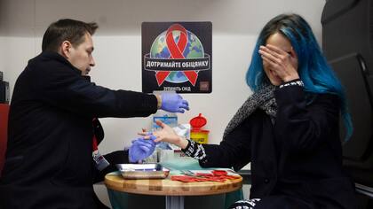 Una mujer se hace una prueba de VIH en un laboratorio móvil para concientizar a la gente sobre el virus, en Kiev, Ucrania