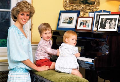 Diana junto a sus hijos William y Harry, en el piano del Kensington Palace