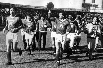 Días después de la coronación en el Nacional 84, otra vuelta olimpica con el trofeo, con Héctor Cúper con el trofeo en alto