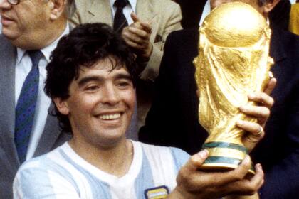 Diego Armando Maradona, con su sonrisa eterna, con la Copa del Mundo en México 86 (DPA-KORR)