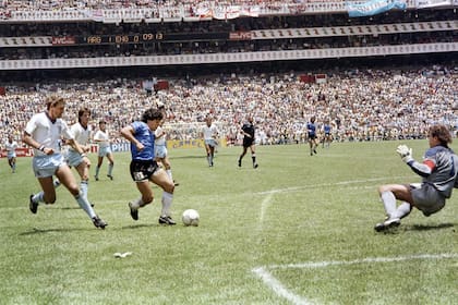 Diego Armando Maradona, seguido por Terry Butcher, enfrenta a Peter Shilton para convertir el segundo gol contra Inglaterra.