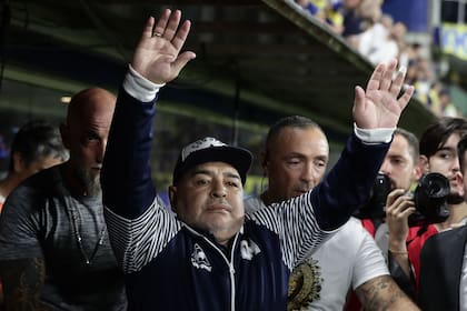 Diego Maradona agradece a los hinchas antes del partido de Superliga 2020 entre Boca Juniors y Gimnasia, en marzo de 2020, y a Carnicer se lo ve a la izquierda 