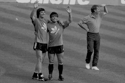 Diego Maradona sonríe con José Basualdo, mientras Carlos Bilardo mira a otro lado