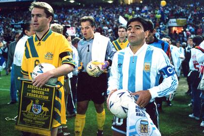 Diego Maradona entra a la cancha junto al capitán australiano Paul Wade, en el partido de repechaje jugado el 31 de octubre de 1993