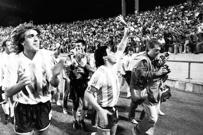 Diego Maradona sostiene la Copa Artemio Franchi en la vuelta olímpica de festejo con los hinchas tras la victoria por penales a Dinamarca en un duelo de campeones continentales, en Mar del Plata; junto a él, Gabriel Batistuta, en 1993.