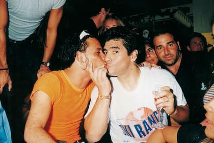 Diego Maradona y Roberto Edgar, cantante de Volcán, a puro pico, en una noche de fiesta.