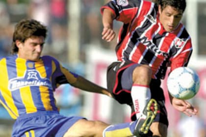 Diego Rivero, con la tricolor de Chacarita, intenta llevarse el balón ante la marca del jugador de Rosario Central, Emiliano Papa