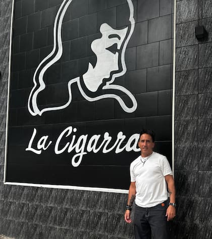 Diego torreiro, socio gerente de La Cigarra, delante de la imagen que identifica su negocio