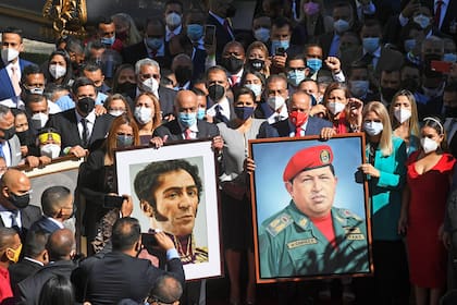 Diputados progubernamentales venezolanos llegan en caravana portando retratos del libertador Simón Bolívar y del fallecido presidente Hugo Chávez al edificio de la Asamblea Nacional para jurar en una ceremonia extraordinaria, en Caracas, el 5 de enero de 2021