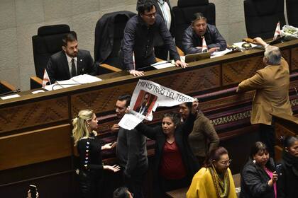 Discusiones en el Parlamento de La Paz. "Ministro del terror", dice el cartel que una opositora muestra al ministro del Interior
