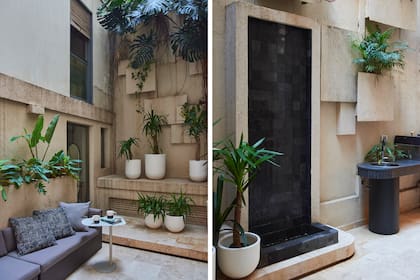 “Diseñamos canteros suspendidos revestidos con Tarquini. Detrás pasamos la iluminación y el riego automático”, contaron las arquitectas. Macetas y plantas (Ciudad Naturaleza). Fuente vertical de piedra Bali negra y piso de mármol Travertino en patrón francés.