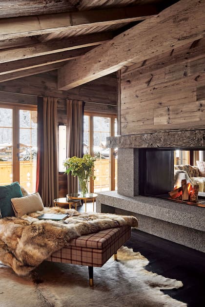 Diseñaron la chimenea que se disfruta de un lado y de otro del living en granito azul con la terminación rústica que da la bujarda (un martillo de cabeza dentada). Chaise longue ‘Spleen’ de India Mahdavi tapizada con género de la exclusiva firma Loro Piana.