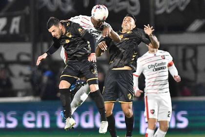 Ditta salta para cabecear entre Horacio Tijanovich y Rodrigo Contreras en Vicente López; Newell's quedó al frente de la Liga Profesional, con un encuentro más que Gimansia, que jugará este domingo en Tucumán.