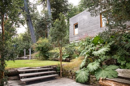 Diversos materiales pueden acompañarse para llevar los desniveles y sectorizar. En este caso lapacho rústico, escalones en listón, y piedra son algunos de los elementos. Los canteros tupidos enmarcan y se abren hacia el pasto que se abre al entorno.