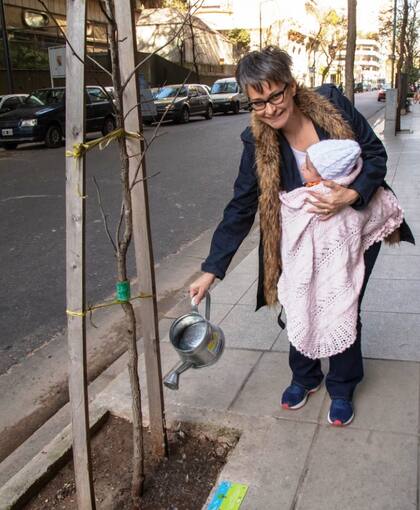 Dolores Dias y Tiziana junto al árbol que plantaron meses después del nacimiento de la beba