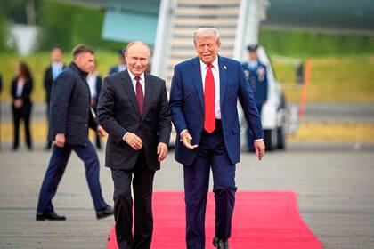 Donald Trump (der.), saluda al presidente ruso, Vladimir Putin, al momento de su llegada a la Base Conjunta Elmendorf-Richardson