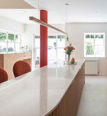 Donde está la puerta que conecta con el patio y llena todo de luz, antes había una ventana estándar. También, se diseñó un mueble de guardado donde ubican con comodidad las bolsas de comida de sus perros.