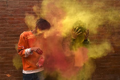 Dos adolescentes juegan con polvos de colores mientras celebran Holi, el festival de colores de primavera, en Katmandú