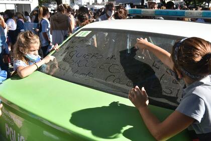 Dos alumnas de primaria escribieron “Quiero ir al colegio. Abran los colegios” sobre el vidrio de un patrullero