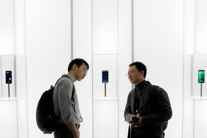 Dos asistentes del Congreso Mundial de Móvil observa el Galaxy S6, el teléfono que Samsung presentó en Barcelona, España