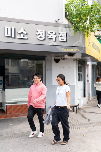 Dos chicos de la nueva generación coreana pasean por la avenida Carabobo