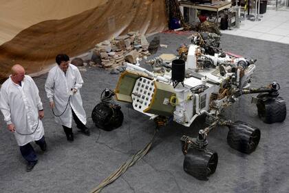 Dos científicos de la NASA junto a un modelo a escala de la sonda Curiosity