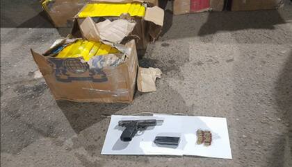 dos de las cajas que contenía la droga, y el nueve milímetros incautado en el movíl
