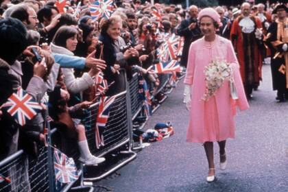 Dos de los trajes que podrán apreciarse en Holyroodhouse: un conjunto rosa de Sir Hardy Amies que la Reina llevó en su Jubileo de Plata, en 1977.