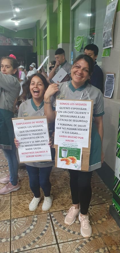 Dos empleadas de Maná se manifiestan en contra de la clausura este lunes, en la vereda, frente al local cerrado con fajas.