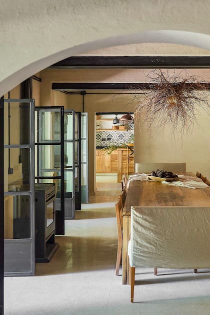 Dos grandes mesas de madera (que se pueden unir o separar) se coronaron con una lámpara de ramas secas (Cecy Flynn).