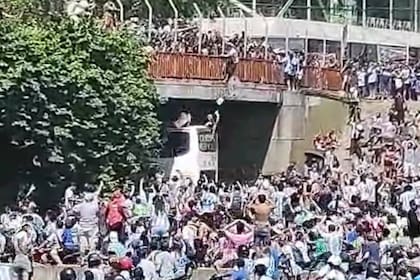 Dos hinchas argentinos quisieron saltar para entrar al colectivo que llevaba a los jugadores en los festejos por el campeonato mundial