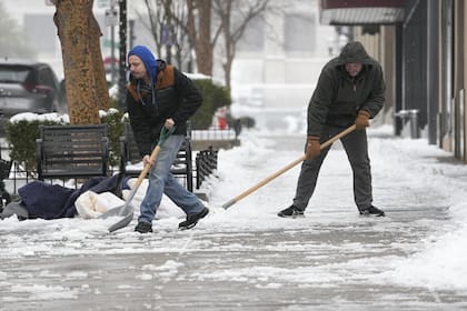 Dos hombres palean nieve el jueves, 18 de enero de 2024, en Nashville, Tennessee
(AP Photo/George Walker IV)