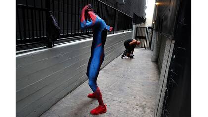 Dos imitadores de Spider-Man, Rashad Rouse, frente, y Juan Carlos Banegas, inmigrante de Honduras,se cambian en el callejón al lado del Teatro Chino TCL después de trabajar en Hollywood Boulevard en Los Ángeles.