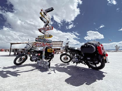 Dos motos Royal Enfield frente a un cartel de direcciones que marcan la aventura que afrontó Roson