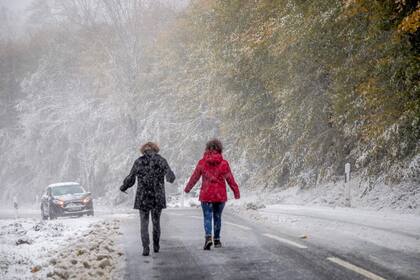 Dos mujeres caminan por el camino resbaladizo hacia su automóvil, a través de la primera nevada cerca de Schmitten en las montañas de Taunus, en el centro de Alemania