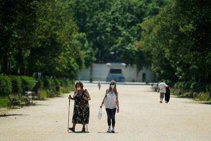 Dos mujeres con máscaras faciales caminan en el parque de la Ciudadela durante las horas permitidas por el gobierno para hacer ejercicio en Barcelona el 30 de mayo de 2020 a medida que el país comienza a aflojar un cierre nacional para evitar la propagación del nuevo coronavirus
