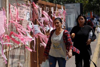 Dos mujeres cruzan frente al edificio del Poder Judicial de Chaco en la calle 9 de Julio, que está tapizado de pedidos de justicia por Cecilia Strzyzowski 