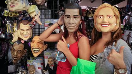 Dos mujeres con máscaras del presidente Barack Obama, y de la candidata demócrata